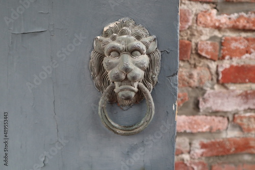 old door knocker of lion on the blue door with retro red brick wall