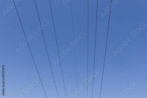 High voltage columns, in the background with blue sky and clouds. Prices of electricity, consumption, ecology.