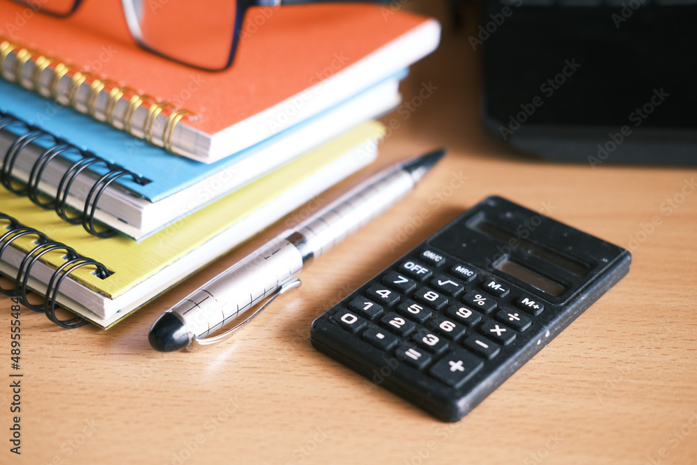 Close up of blue calculator and notepad on color background Close up of blue calculator and notepad on color background