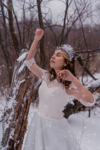 girl in a white dress in the snow in winter