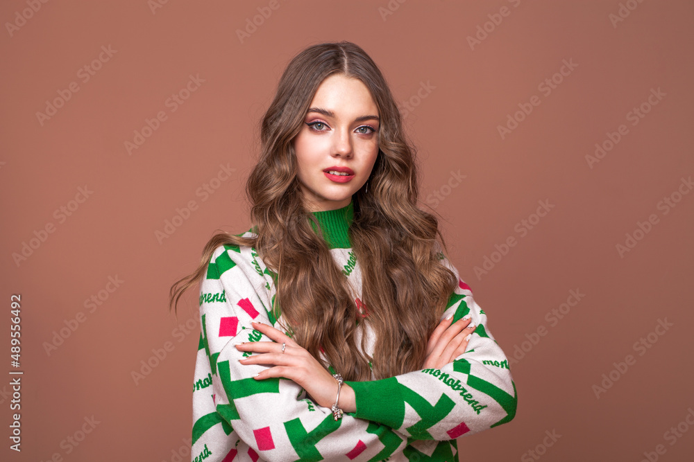 Portrait of a young beautiful teenage girl on a beige isolated background