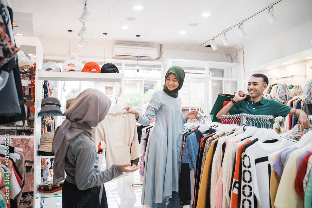 asian muslim family buying new clothes together in clothing store asian muslim family buying new clothes together in clothing store