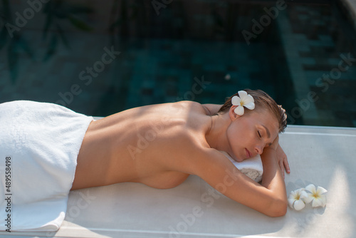 Young beautiful girl relaxes near the pool, spa.