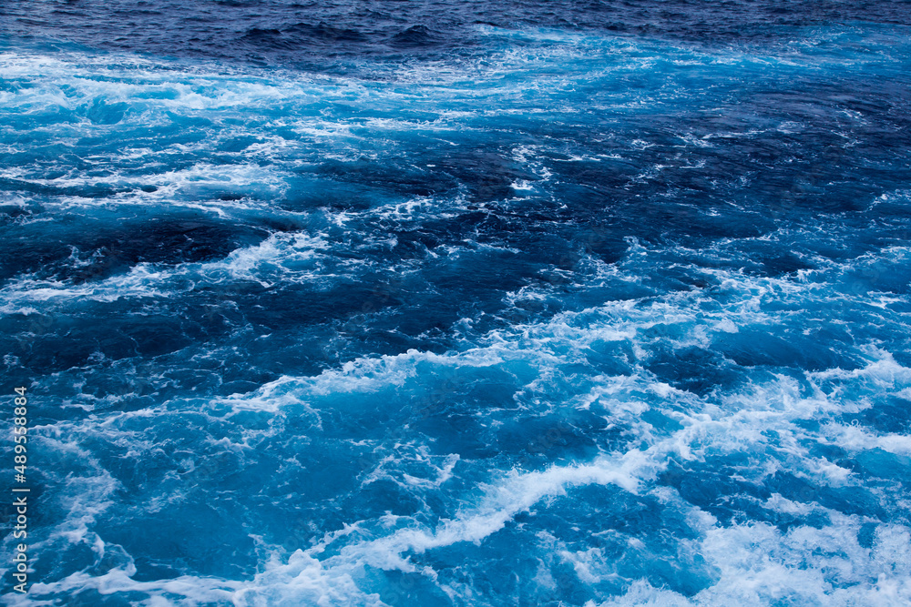 Ocean close up. Background of blue water with white foam. Ocean close up. Background of blue water with white foam.