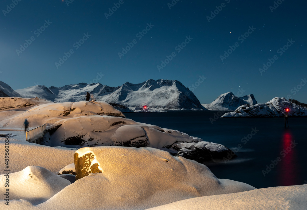 photographer waiting for northern lights near village Hamn on Senja island in Norway on a clear cold winter day