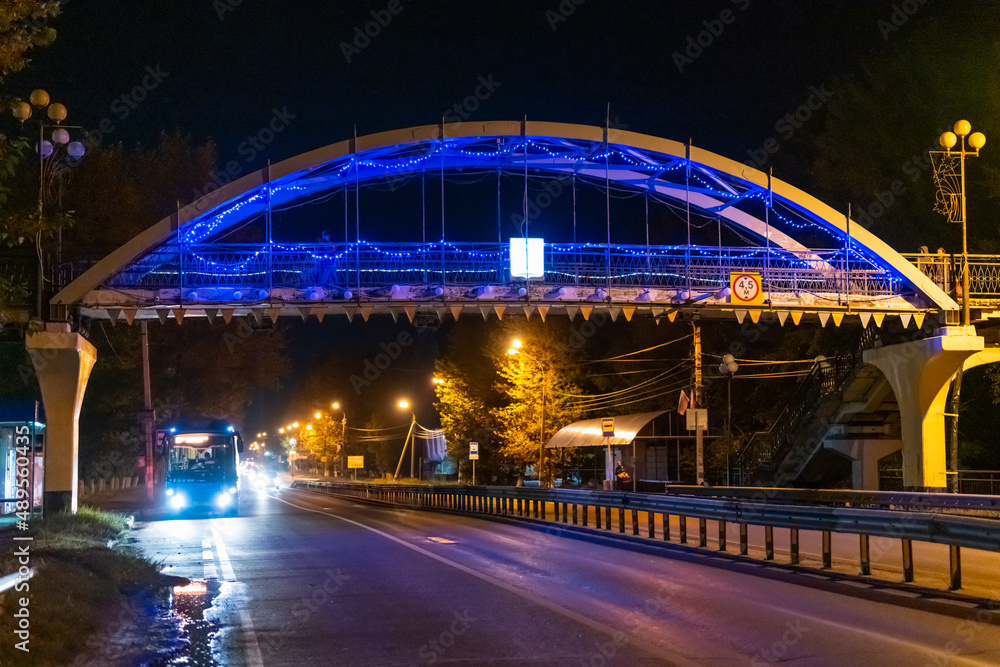 Public transport on the background of the bridge at night. Night highway.
