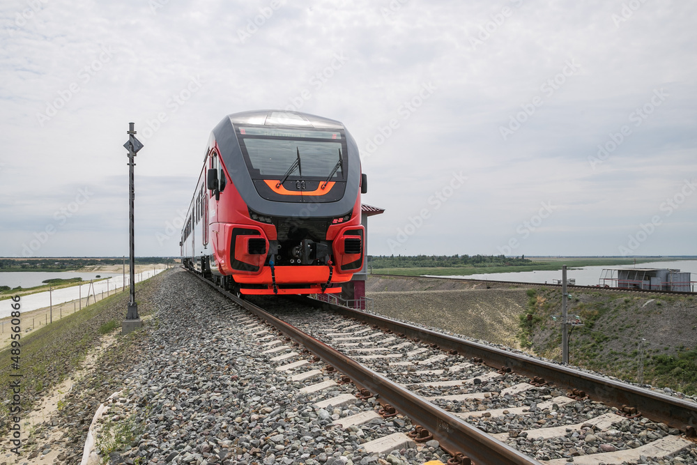 New red high-speed train for traveling around the country. new railway bridge across the river