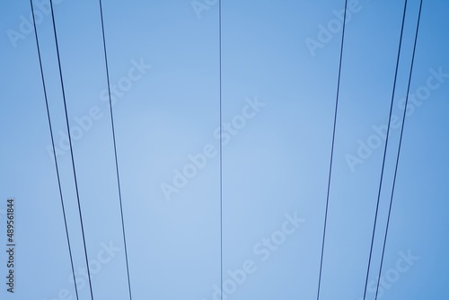 High voltage columns, in the background with blue sky and clouds. Prices of electricity, consumption, ecology.