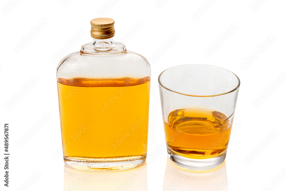 Glass whiskey hip flask, or whisky or bourbon, near a glass of whiskey isolated on white, clipping path Glass whiskey hip flask, or whisky or bourbon, near a glass of whiskey isolated on white, clipping path