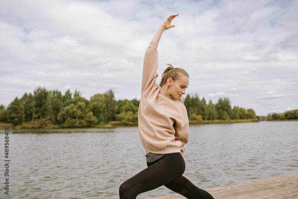 Portrait of young attractive woman practicing yoga by the lake in the morning. Portrait of young attractive woman practicing yoga by the lake in the morning.
