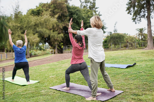 Multiracial people doing yoga exercise ourdoor - Healthy life balance concept photo