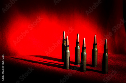 Obraz na płótnie Abstract image of military bullets on a background of blood color. A place for an inscription. (War in Ukraine - concept) w salonie
