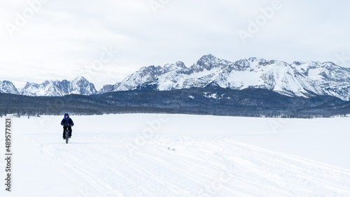Man rides a fat tire bike on the snow with Idaho Sawtooth Mountain backdrop