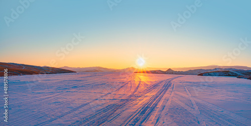 Lake Baikal road on ice to Olkhon island - Drifting snow on winter road with snowdrifts on the roadside in the snowstorm