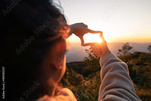 New year planning and vision concept, Close up of woman hands making frame gesture with sunset, Female capturing the sunrise. copy space.