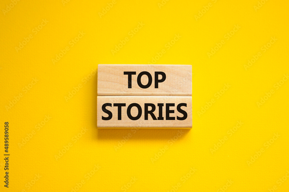 Top stories symbol. Concept words Top stories on wooden blocks on a beautiful yellow table yellow background. Business story and top stories concept, copy space. Top stories symbol. Concept words Top stories on wooden blocks on a beautiful yellow table yellow background. Business story and top stories concept, copy space.