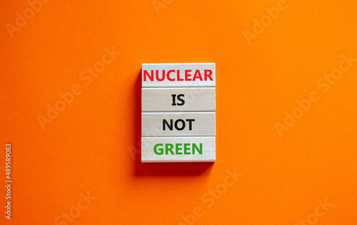 Nuclear is not green symbol. Concept words Nuclear is not green on wooden blocks. Beautiful orange table orange background. Nuclear is not green business concept. Copy space.