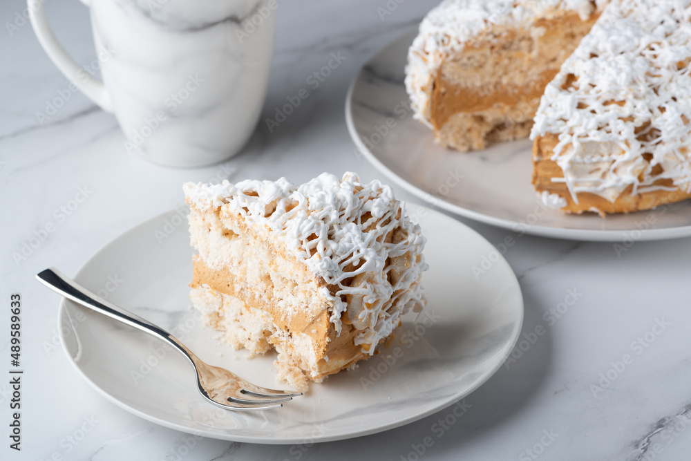 A piece of delicious vanilla cake and cake on a light table A piece of delicious vanilla cake and cake on a light table