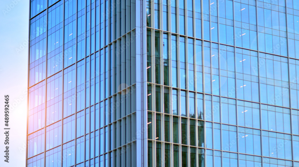 Urban abstract - windowed wall of office building. Detail shot of modern business building in city. Looking up at the glass facade of a skyscraper. Urban abstract - windowed wall of office building. Detail shot of modern business building in city. Looking up at the glass facade of a skyscraper.