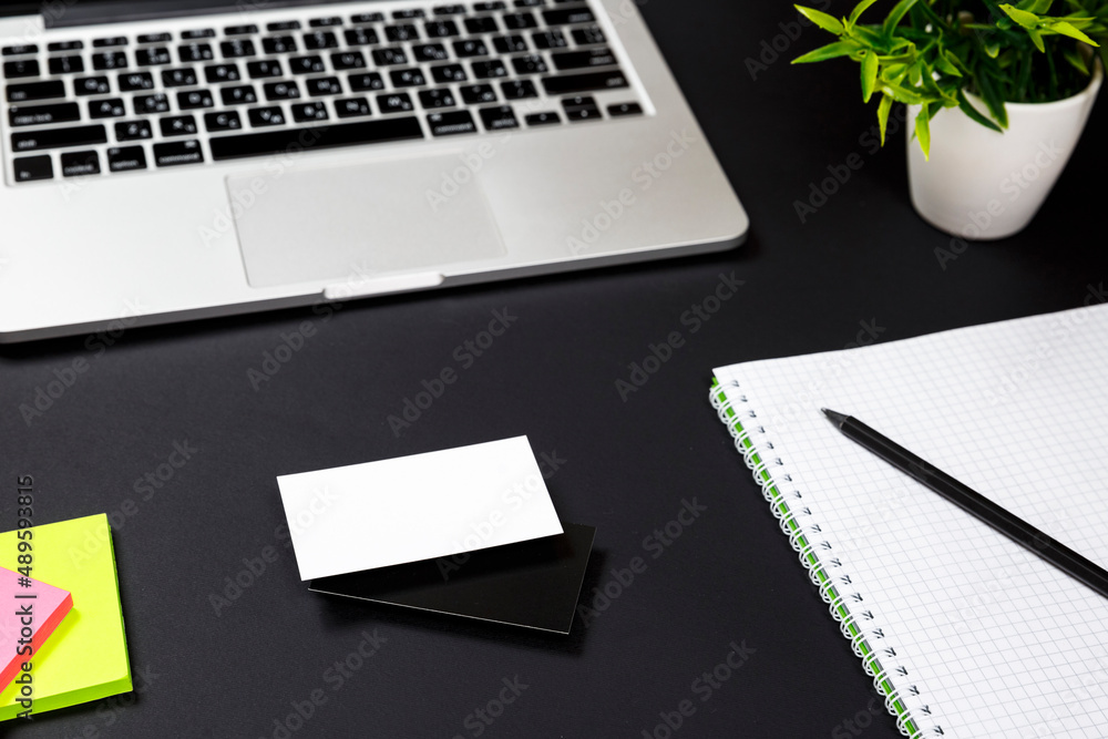 White blank business card stationery on black desktop with office supplies White blank business card stationery on black desktop with office supplies