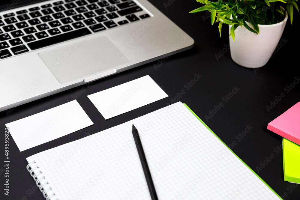 White blank business card stationery on black desktop with office supplies White blank business card stationery on black desktop with office supplies
