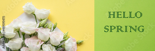 Hello Spring hand lettering inscription and eustoma flowers on bright yellow background. Lettering spring season.web banner.stylish flat lay. soft light, tenderness atmospheric moment. © Yulia