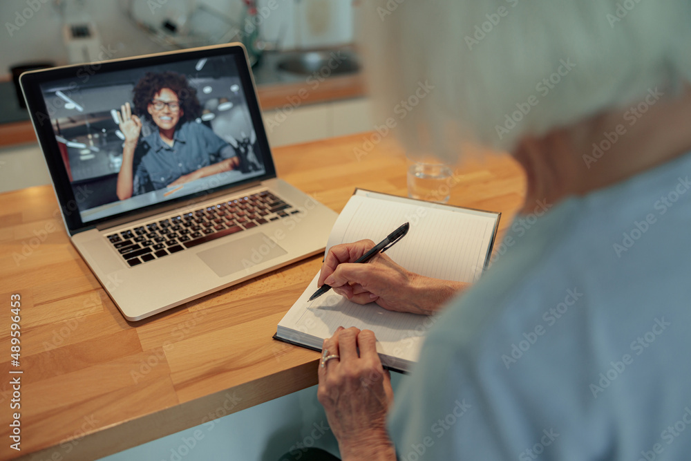Aged woman having webcam call on laptop indoors Aged woman having webcam call on laptop indoors