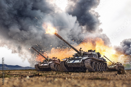 Fotografie Group of main battle tanks with a city on fire on the background