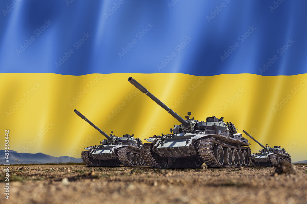 Tanks lined up in front of a Ukrainian flag. Several military army war  battle tank vehicles on the terrain ready to attack Stock Photo