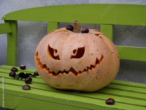 Künstlerisch geschnitzte Kürbislaterne zu Halloween mit Augen und Mund mit Zähnen als Motiv