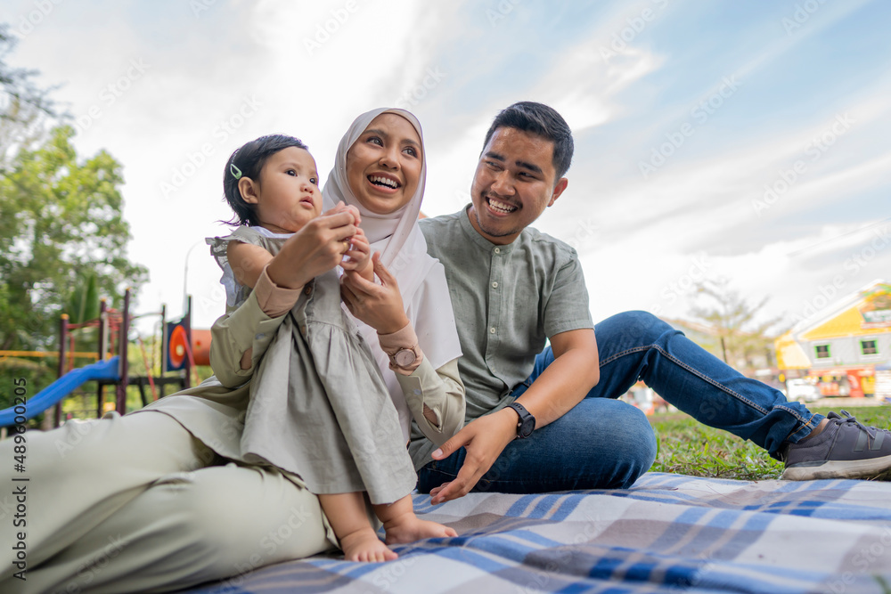 Happy Muslim Family Have A Picnic Outdoor  - obrazy, fototapety, plakaty 