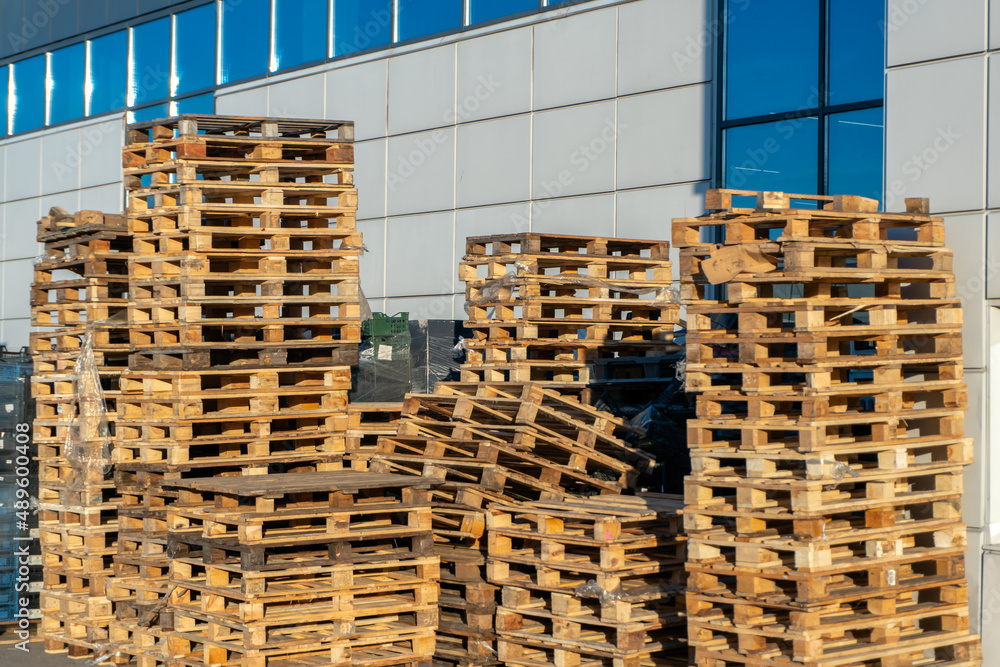 Stacked wooden pallets at a storage or near a shop Stacked wooden pallets at a storage or near a shop