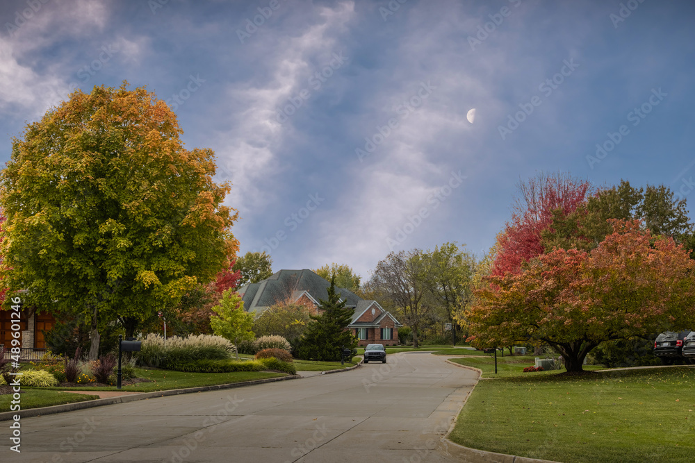 View of Midwestern neighborhood early in the evening in autumn; rising moon above