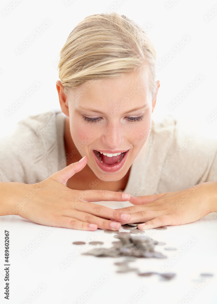 Its all mine. Shot of a beautiful woman looking at coins on the table in front of her. Its all mine. Shot of a beautiful woman looking at coins on the table in front of her.
