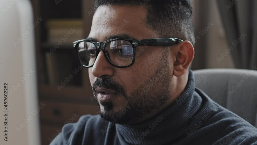 Close up shot of middle eastern businessman in glasses talking on online video call on computer Close up shot of middle eastern businessman in glasses talking on online video call on computer
