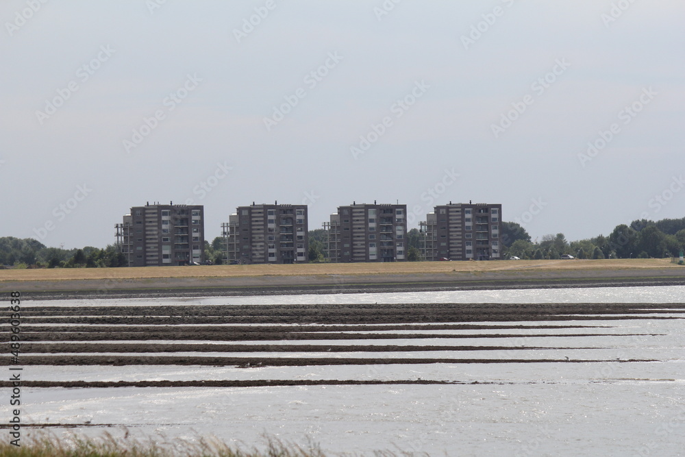 a part of the skyline of terneuzen at the seaside with four square shaped residential towers at the seawall with a beautiful view at the westerschelde sea a part of the skyline of terneuzen at the seaside with four square shaped residential towers at the seawall with a beautiful view at the westerschelde sea
