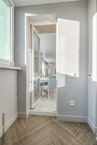 long corridor in interior of entrance hall of modern apartments with doors, cabinets, shelves and a mirror