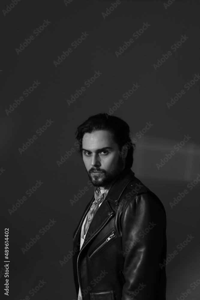 Bearded stylish handsome confident man posing indoor. Black and white photo.