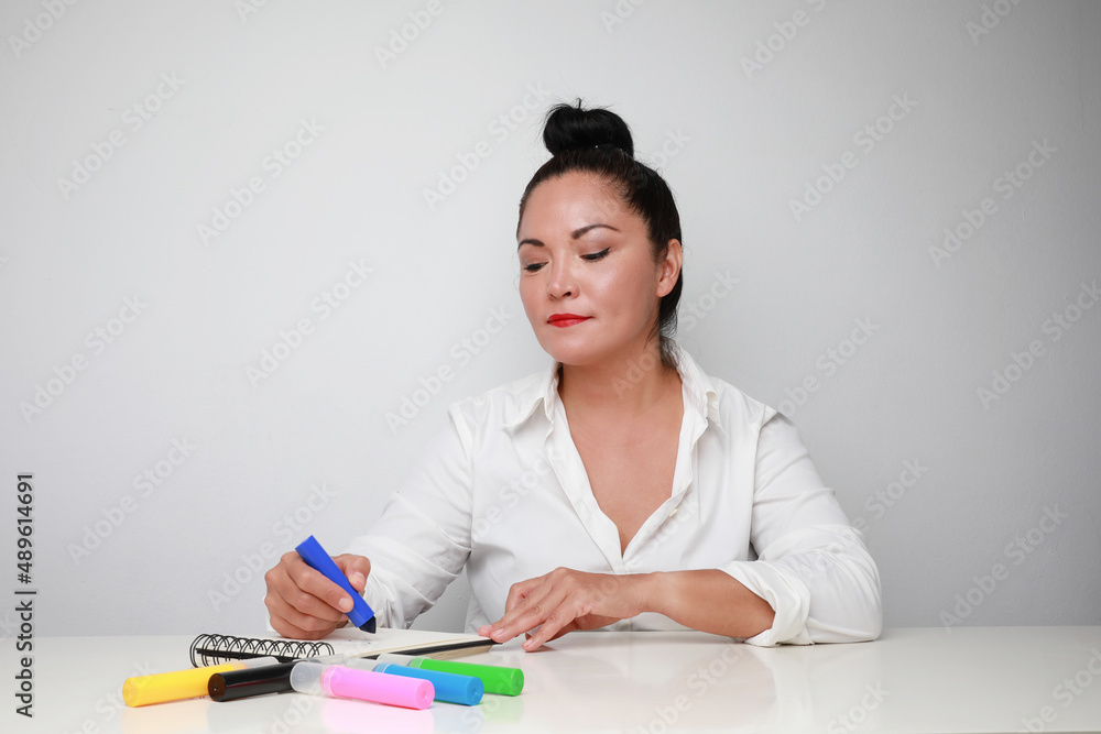 Portrait of brunette middle age woman drawing small pictures. Isolated. Portrait of brunette middle age woman drawing small pictures. Isolated.