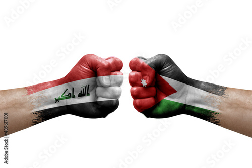 Two hands punch to each others on white background. Country flags painted fists, conflict crisis concept between iraq and jordan
