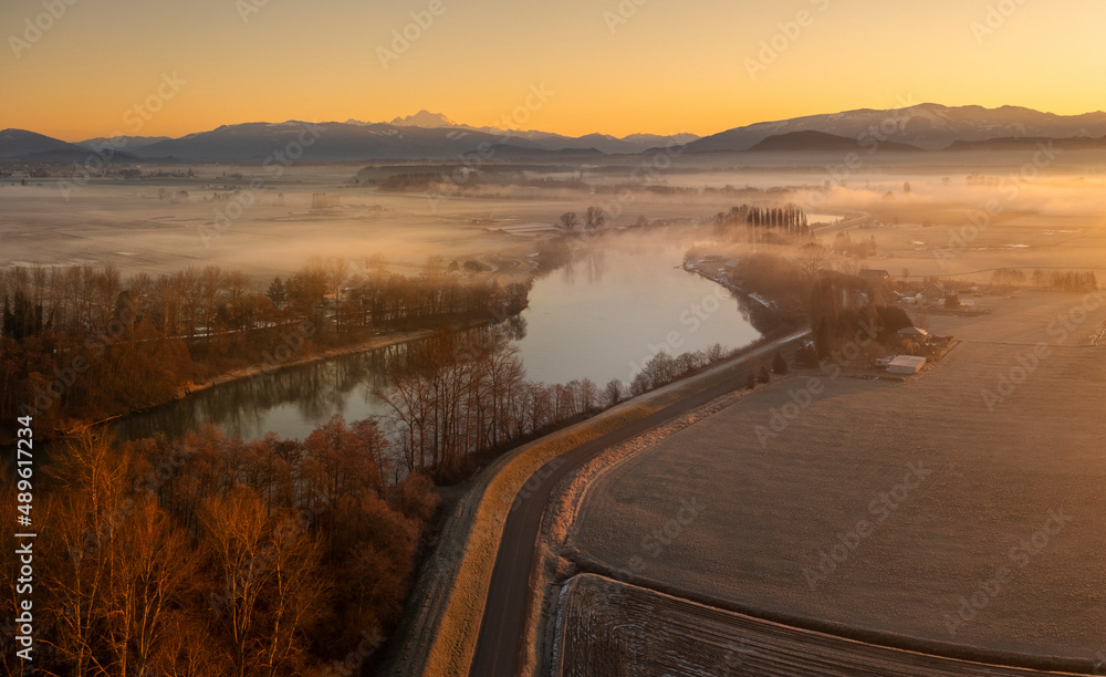 Aerial View of the Skagit River During a Brilliant Sunrise. The Skagit River runs from high in the Cascade Mountains to Puget Sound. The Skagit floodplain is one of the richest agricultural areas. Aerial View of the Skagit River During a Brilliant Sunrise. The Skagit River runs from high in the Cascade Mountains to Puget Sound. The Skagit floodplain is one of the richest agricultural areas.