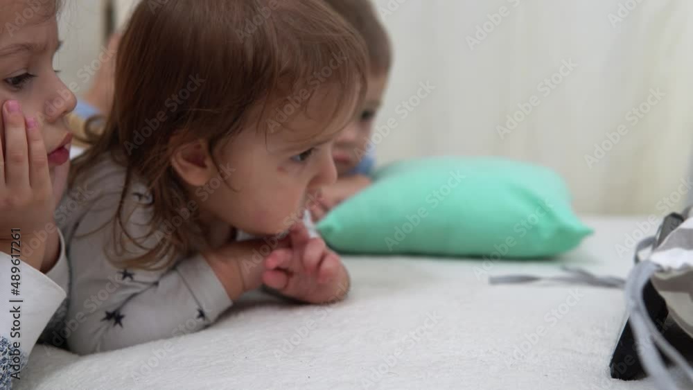 Smiling Preschool Toddler Children In Pajamas Watching Cartoon on Smartphone on Bed. Siblings Little Twins Boy and Girl Have Fun. Happy Kids On Quarantine At Home. Friendship, Family, Education Smiling Preschool Toddler Children In Pajamas Watching Cartoon on Smartphone on Bed. Siblings Little Twins Boy and Girl Have Fun. Happy Kids On Quarantine At Home. Friendship, Family, Education