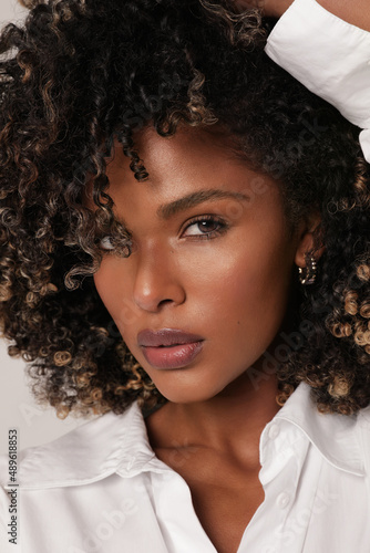 Attractive African American young woman smiling with curly black hair. Close-up.