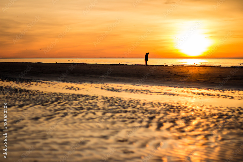 lonely human figure on a background of sunset at the sea