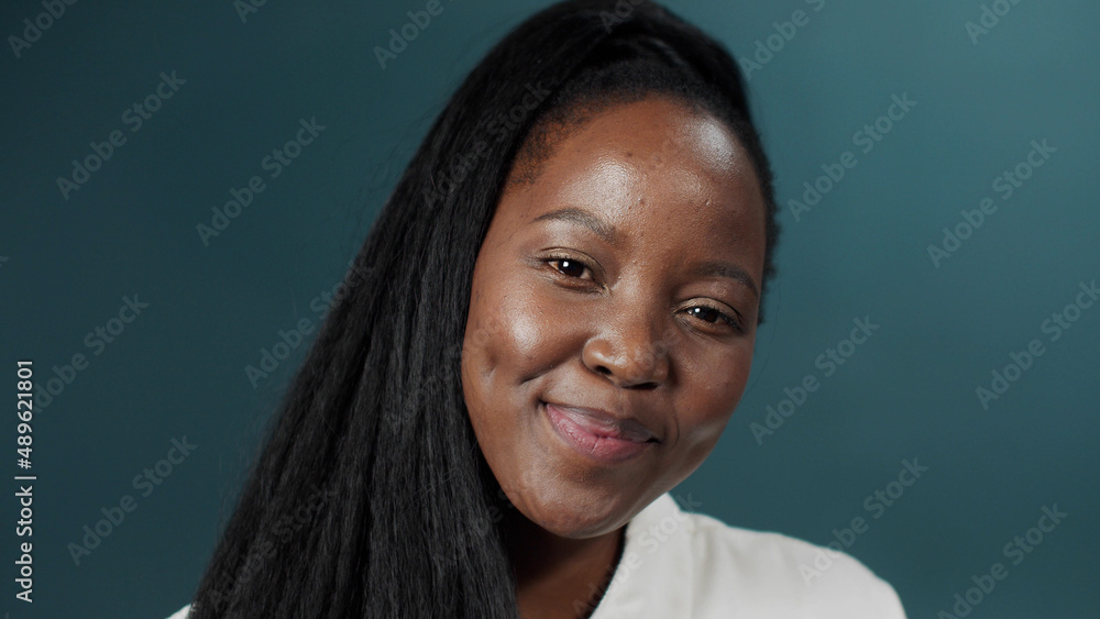 Black female with long hair posing over green studio background, smiling Black female with long hair posing over green studio background, smiling