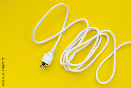Electrical plug on yellow background.