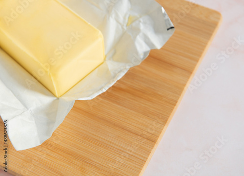 Cutting board with a block of butter unwrapped photo