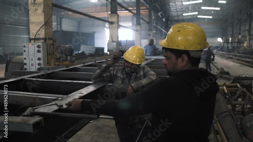 Team of welder working factory in india with heavy metals iron steel for truck trailers production line manufacturing photo