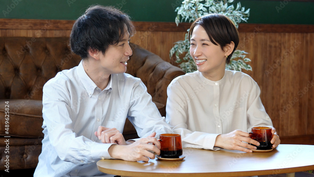 コーヒーを飲みながら雑談をするカップル コーヒーを飲みながら雑談をするカップル