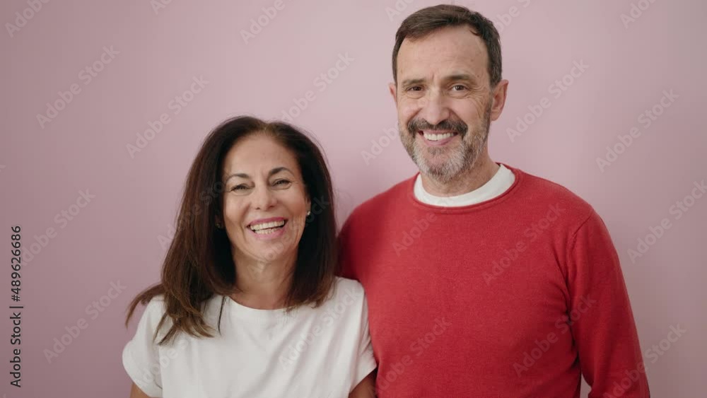 Man and woman couple hugging each other standing over pink background Man and woman couple hugging each other standing over pink background